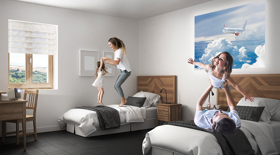 a family enjoy staycation in a hotel with a portable projector
